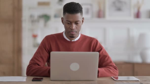 African Man Εμφάνιση αντίχειρων Down Sign Ενώ χρησιμοποιείτε Laptop στο Office — Αρχείο Βίντεο