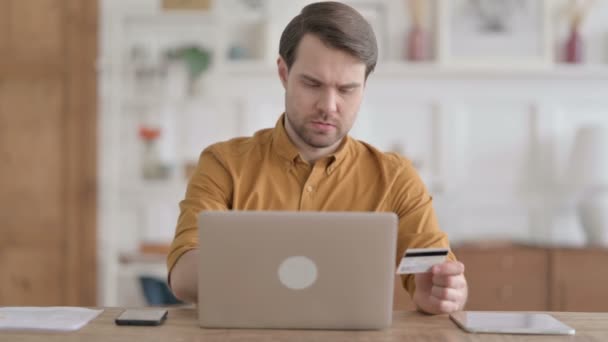 Молодий чоловік робить успішні онлайн платежі на ноутбуці — стокове відео