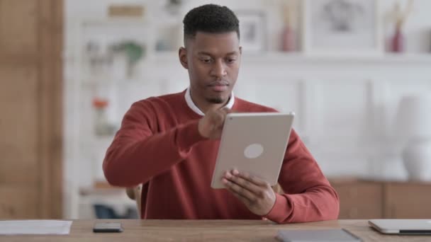 Hombre africano usando Tablet mientras está sentado en la oficina — Vídeos de Stock