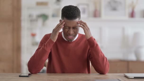 Hombre africano con dolor de cabeza mientras piensa en la oficina — Vídeo de stock