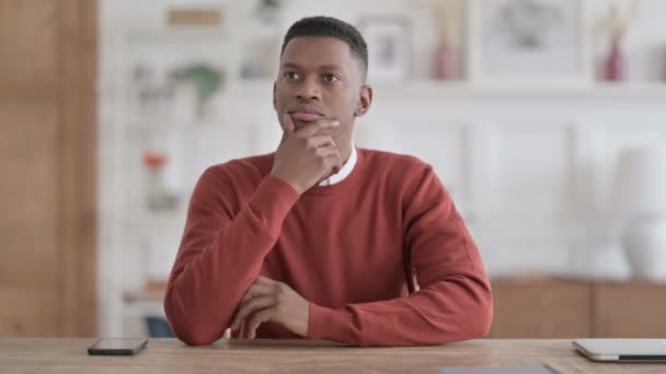 Pensive homme africain pensant tout en étant assis dans le bureau — Video
