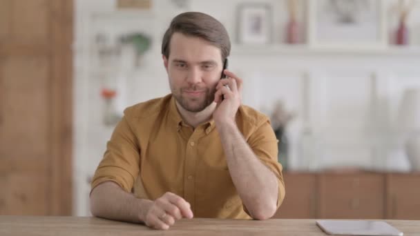 Jeune homme parlant au téléphone au bureau — Video