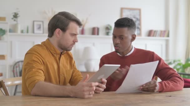 Afrikaanse man en jonge man werken met tabletten en documenten — Stockvideo