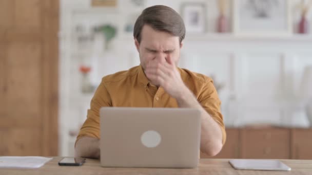 У молодої людини головний біль під час роботи на ноутбуці — стокове відео