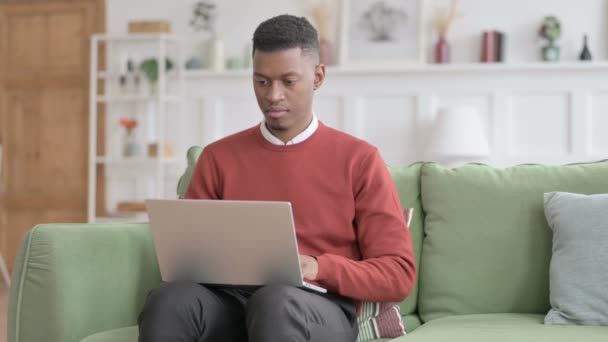 Afrikansk man pekar mot kameran när du använder laptop i Office — Stockvideo