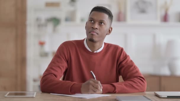 Uomo africano avendo fallimento durante la scrittura su carta in carica — Video Stock