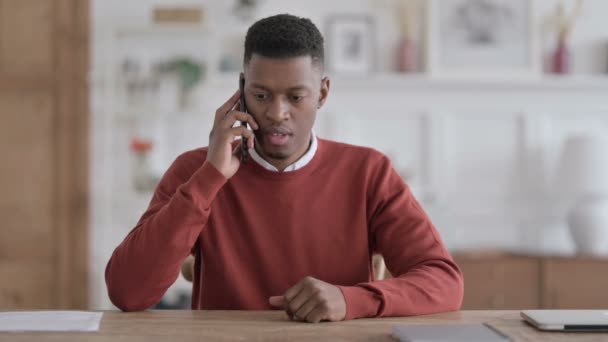 Homme africain en colère Parler au téléphone sur le canapé — Video