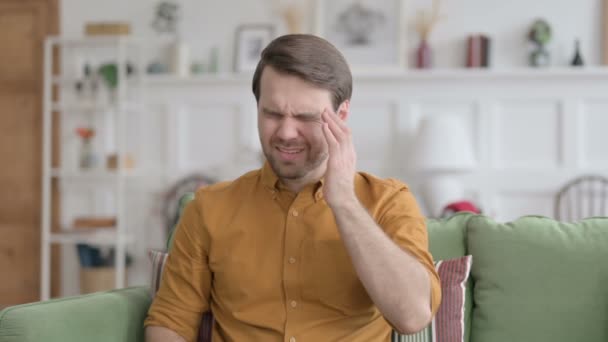Homem jovem com dor de cabeça em casa — Vídeo de Stock