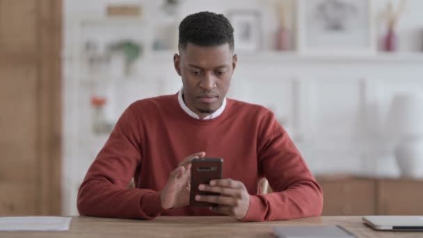 Atrakcyjne African Man za pomocą smartfona w biurze — Wideo stockowe