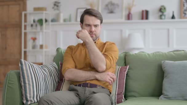 ソファに座りながら考える若い男 — ストック動画