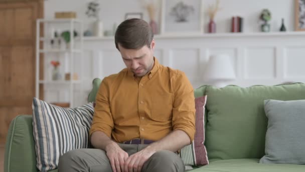 Ο νεαρός άνδρας κλαίει ενώ κάθεται στον καναπέ — Αρχείο Βίντεο