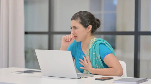 Femme indienne tousse tout en utilisant un ordinateur portable au bureau — Photo