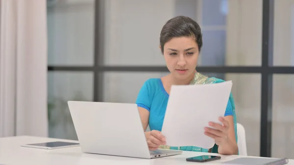 Donna indiana con i documenti di lettura del computer portatile in ufficio — Foto Stock