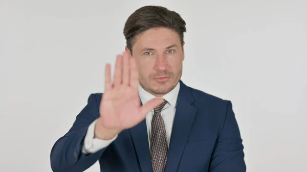 Uomo d'affari di mezza età che mostra stop segno a mano, sfondo bianco — Foto Stock