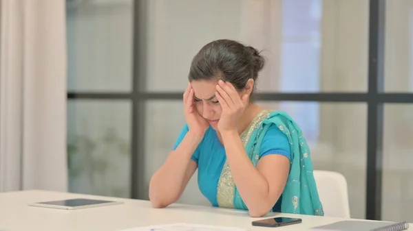 Розчарована індійська жінка відчуває страх, сидячи в офісі — стокове фото