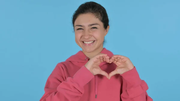 Indiai lány bemutató szív alakú kéz, kék háttér — Stock Fotó