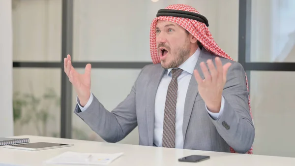 Upprörd medelålders arabisk affärsman känner oro när du sitter i ämbetet — Stockfoto