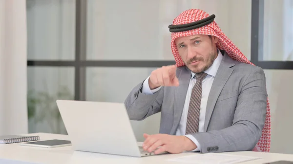 Medelålders arabisk affärsman Peka på kameran när du använder laptop i Office — Stockfoto