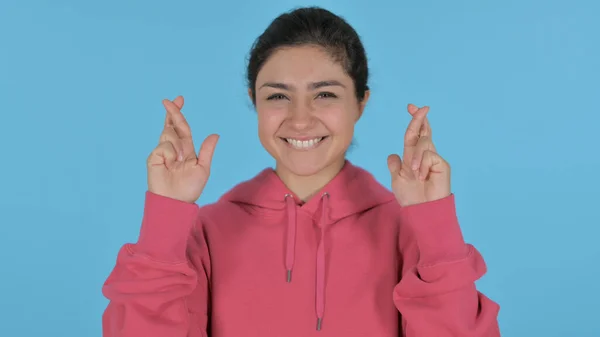 Fille indienne priant avec les doigts croisés, fond bleu — Photo