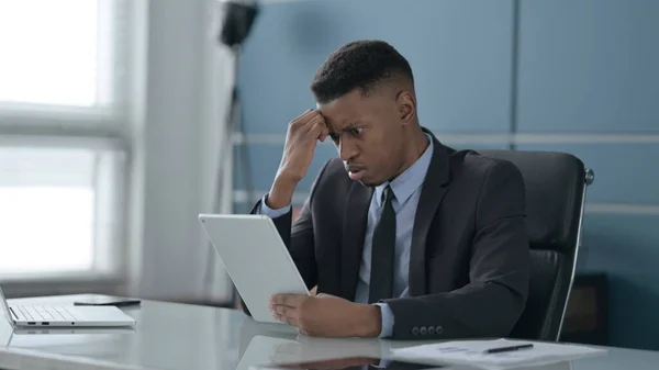 Un om de afaceri african reacționează la pierderea pe tabletă în birou — Fotografie, imagine de stoc