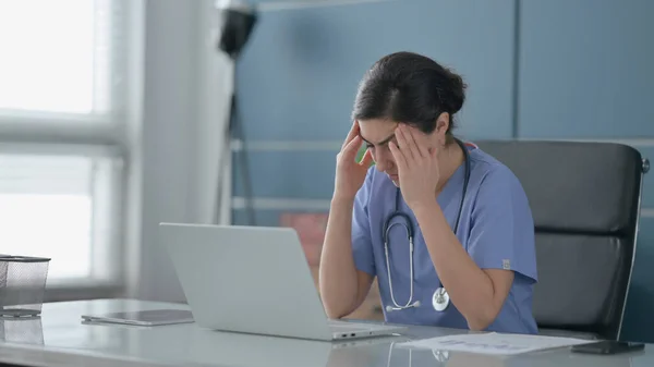 Indian Kobieta lekarz mając ból głowy podczas pracy na laptopie — Zdjęcie stockowe