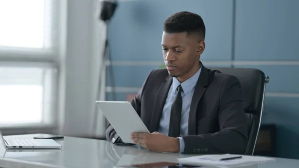 Afrikanischer Geschäftsmann nutzt Tablet im Büro — Stockfoto