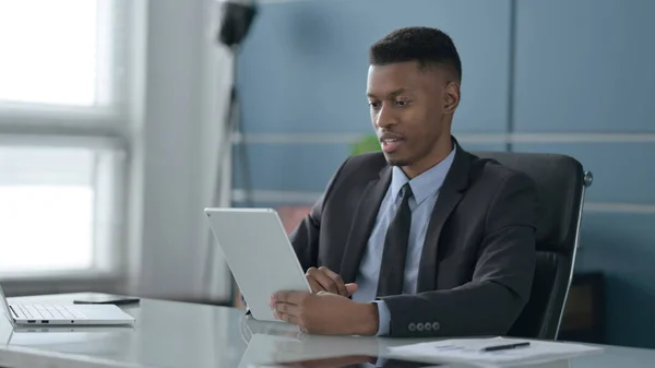 Afrikanischer Geschäftsmann macht Videoanruf auf Tablet im Büro — Stockfoto