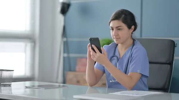 Indiase vrouwelijke arts met behulp van Smartphone in Office — Stockfoto