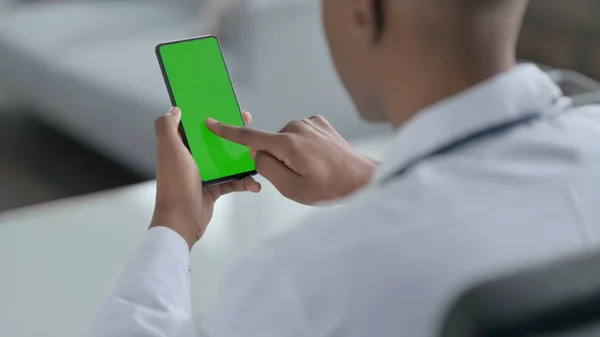 Afrikanischer Arzt benutzt Smartphone mit grünem Bildschirm — Stockfoto