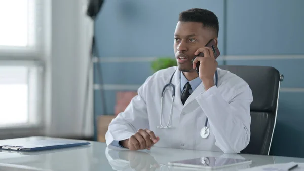 Afrikansk doktor talar på Smartphone i Office — Stockfoto