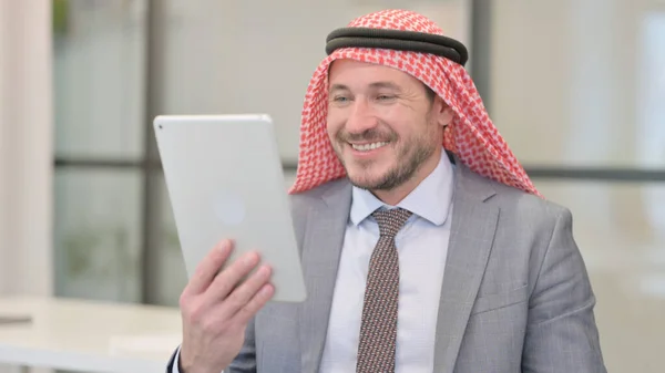 Портрет відеодзвінка на планшет середнього віку арабський бізнесмен в офісі — стокове фото