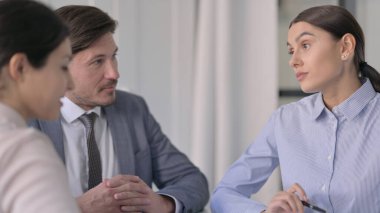 Ofiste otururken iş arkadaşlarıyla konuşan Hintli iş kadını