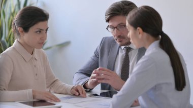 Ciddi Erkek ve Kadın İş Adamları Kağıtlarla Tartışıyor