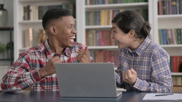 Afrikai férfi és indiai nő ünnepli a sikert a laptopon — Stock Fotó