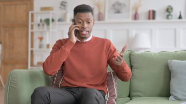 Kızgın Afrikalı adam telefonda konuşuyor.
