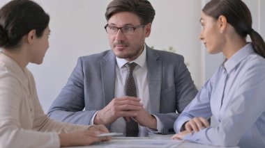 İş adamları ofiste sohbet ediyorlar.