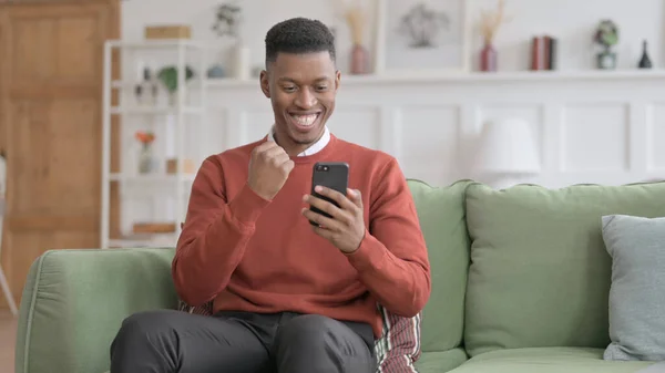 African Man ayant du succès sur Smartphone à la maison — Photo
