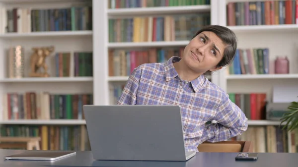 Mulher indiana tendo dor nas costas ao usar laptop no escritório — Fotografia de Stock