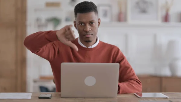 Afrikai Man Mutasd hüvelykujj lefelé jel használata közben Laptop az irodában — Stock Fotó