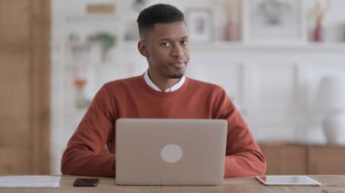 Ofiste dizüstü bilgisayar kullanırken Kafasını Sallayan Afrikalı Adam İşaret Yok