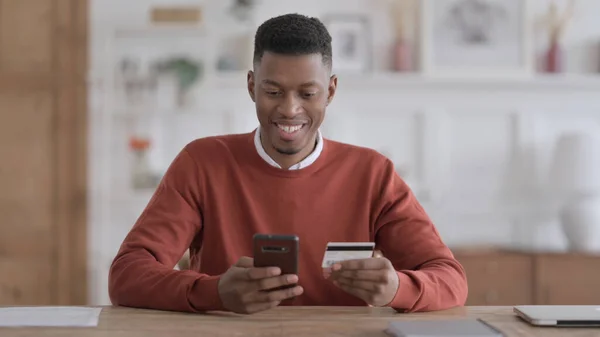 非洲男人在智能手机上的在线支付成功 — 图库照片
