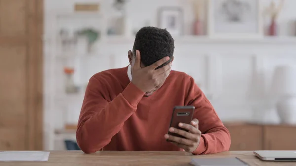 Naštvat Afričana reagujícího na ztrátu na chytrém telefonu — Stock fotografie