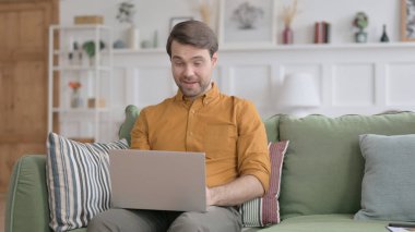 Genç adam video çekiyor. Dizüstü bilgisayarda arıyor.