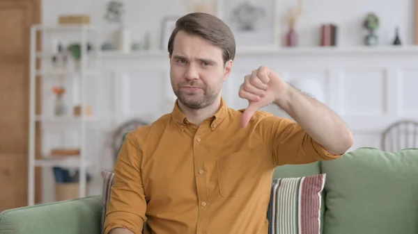 Портрет молодого человека, показывающего пальцы дома — стоковое фото