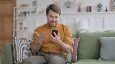 Genç adam evde akıllı telefondan kayboluyor.