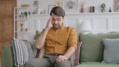 Orta yaşlı iş adamı koltukta otururken baş ağrısı çekiyor