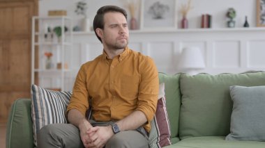 Genç adam kanepeye geliyor.