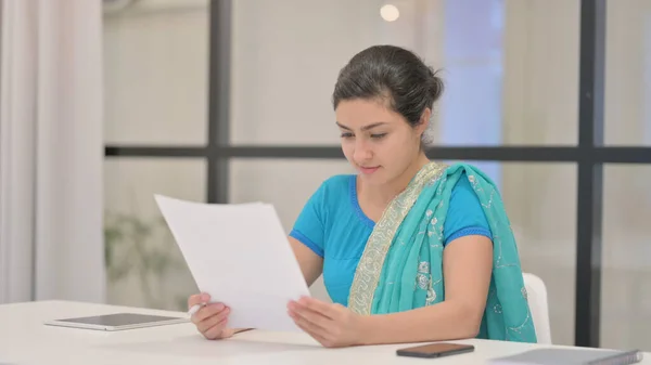 Indiano donna lettura rapporti mentre seduta in ufficio — Foto Stock