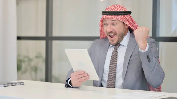 Medelålders arabisk affärsman firar framgång på Tablet in Office — Stockfoto