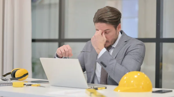 Ingeniero de mediana edad que tiene dolor de cabeza mientras trabaja en el ordenador portátil — Foto de Stock